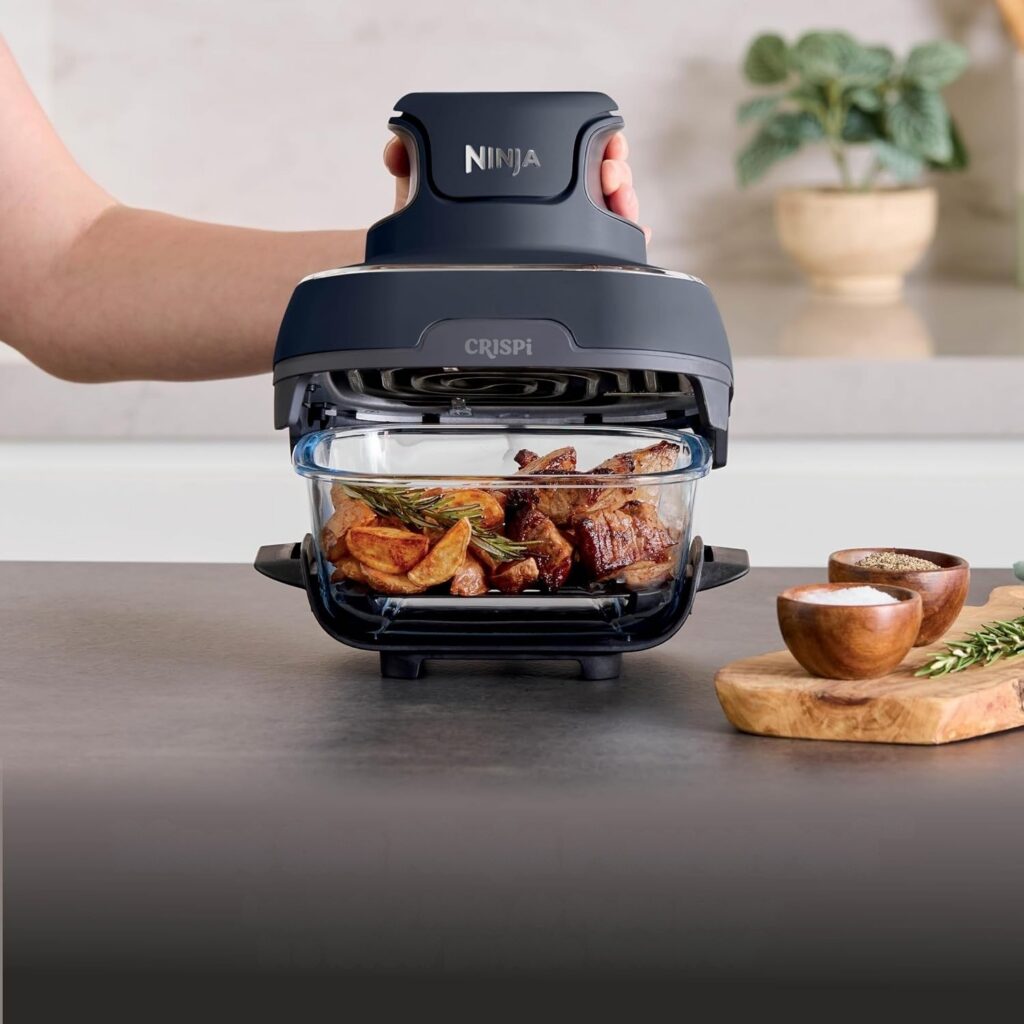 Ninja Crispi 4-in-1 glass air fryer with steak and potatoes in the glass container